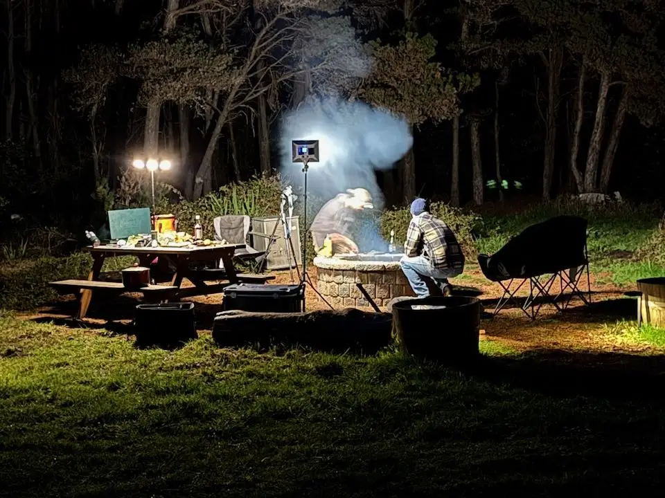 Camp at night during Camp Catch n Cook, lit up around the tables and the fire